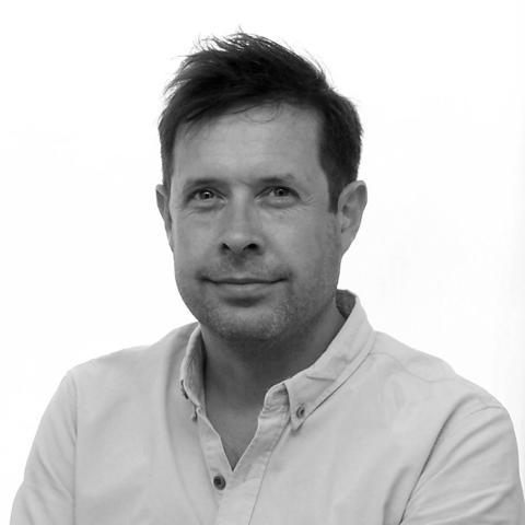 A black and white portrait of a man with short hair.