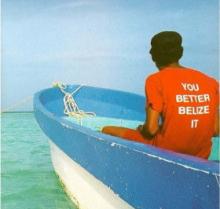 Image of a man's back on a blue row boat over a blue sea and sky. He wears an orange shirt that reads, in white text: "YOU BETTER BELIZE IT"